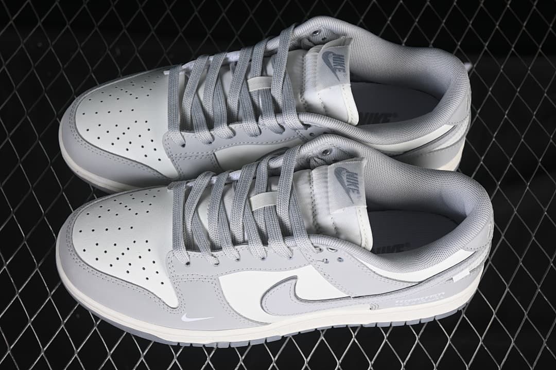 Overhead view of a pair of gray and white Nike SB Dunk Low sneakers showing the perforated toe panels and laces.