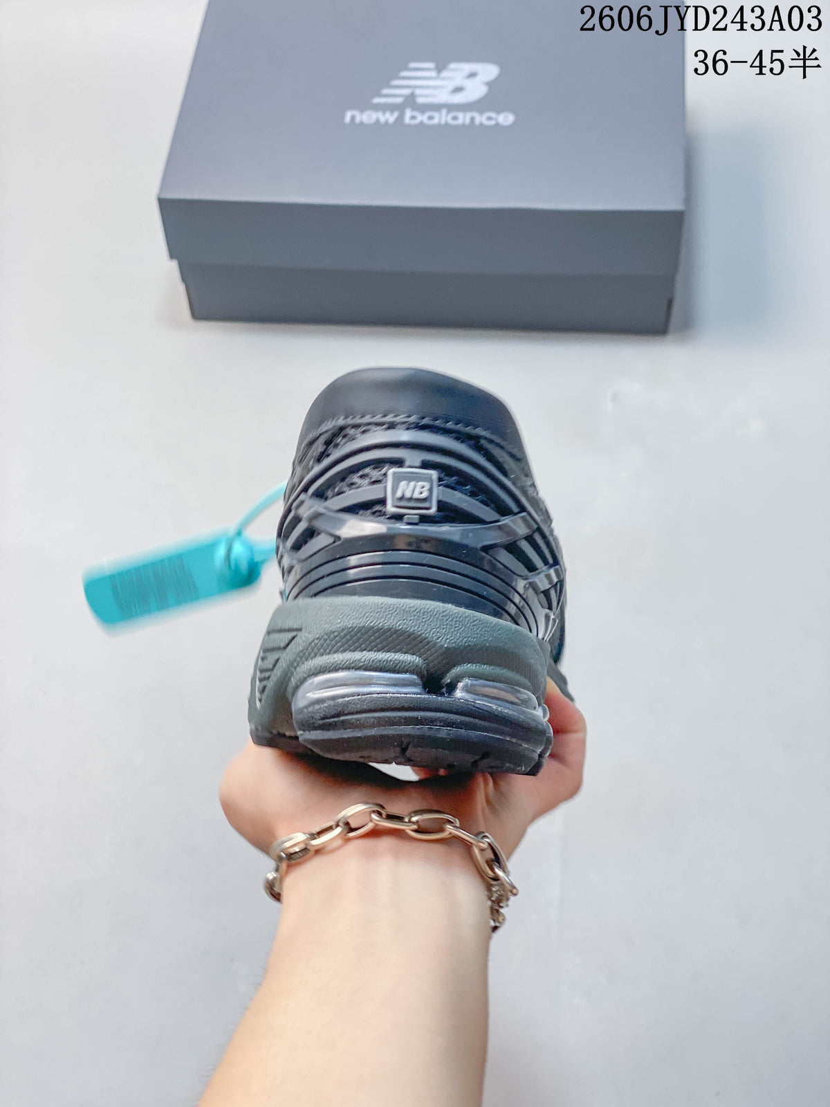 Rear view of the charcoal gray New Balance 1906L shoe showing its heel and outsole