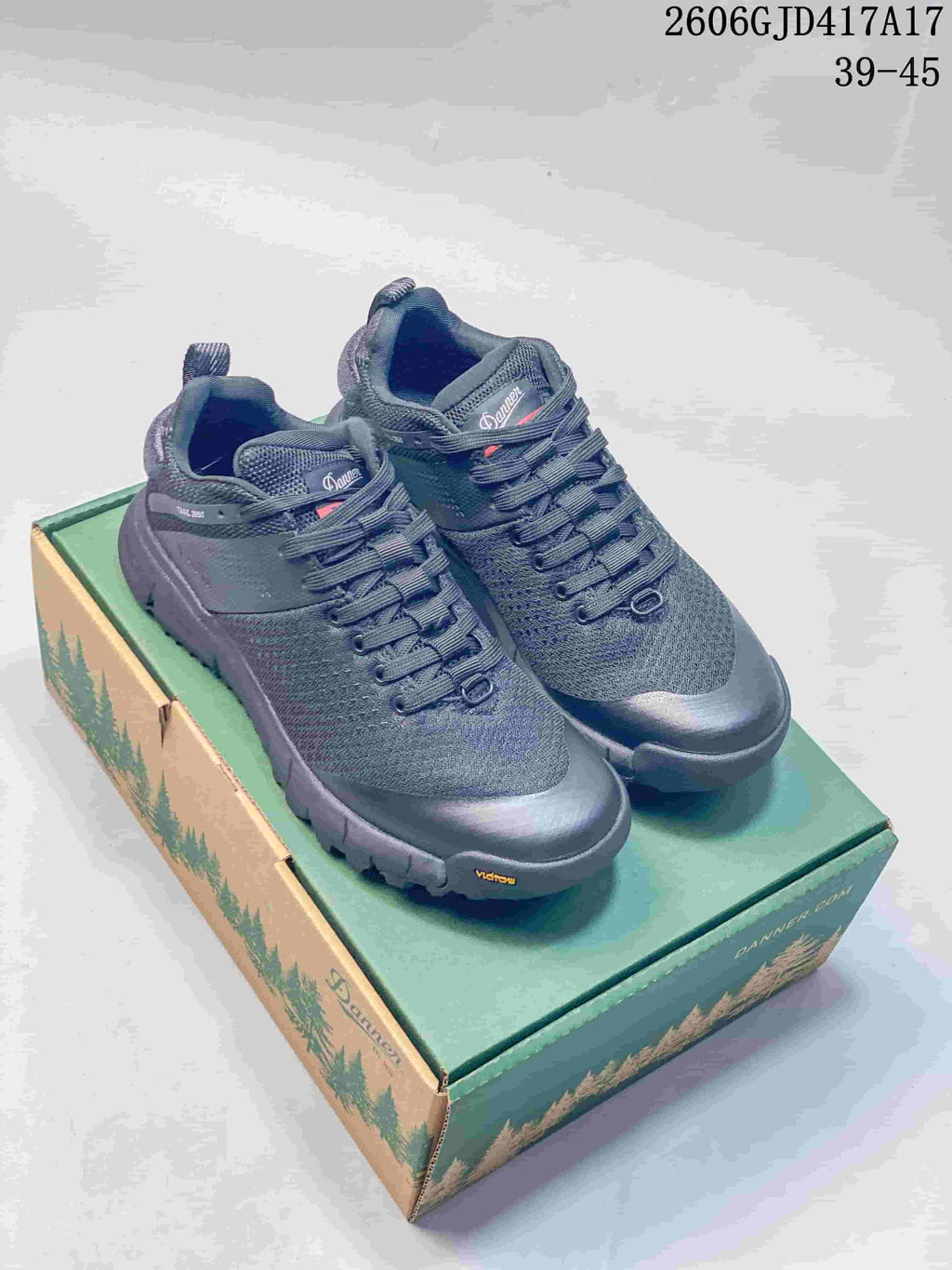 Pair of dark gray low-cut Danner shoes with lace-up fronts on a green and tan shoe box.