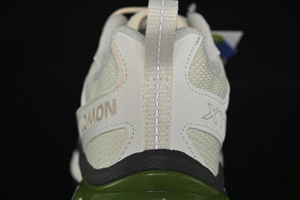 Rear view showing the heel pull loop, branding, and green midsole detail.