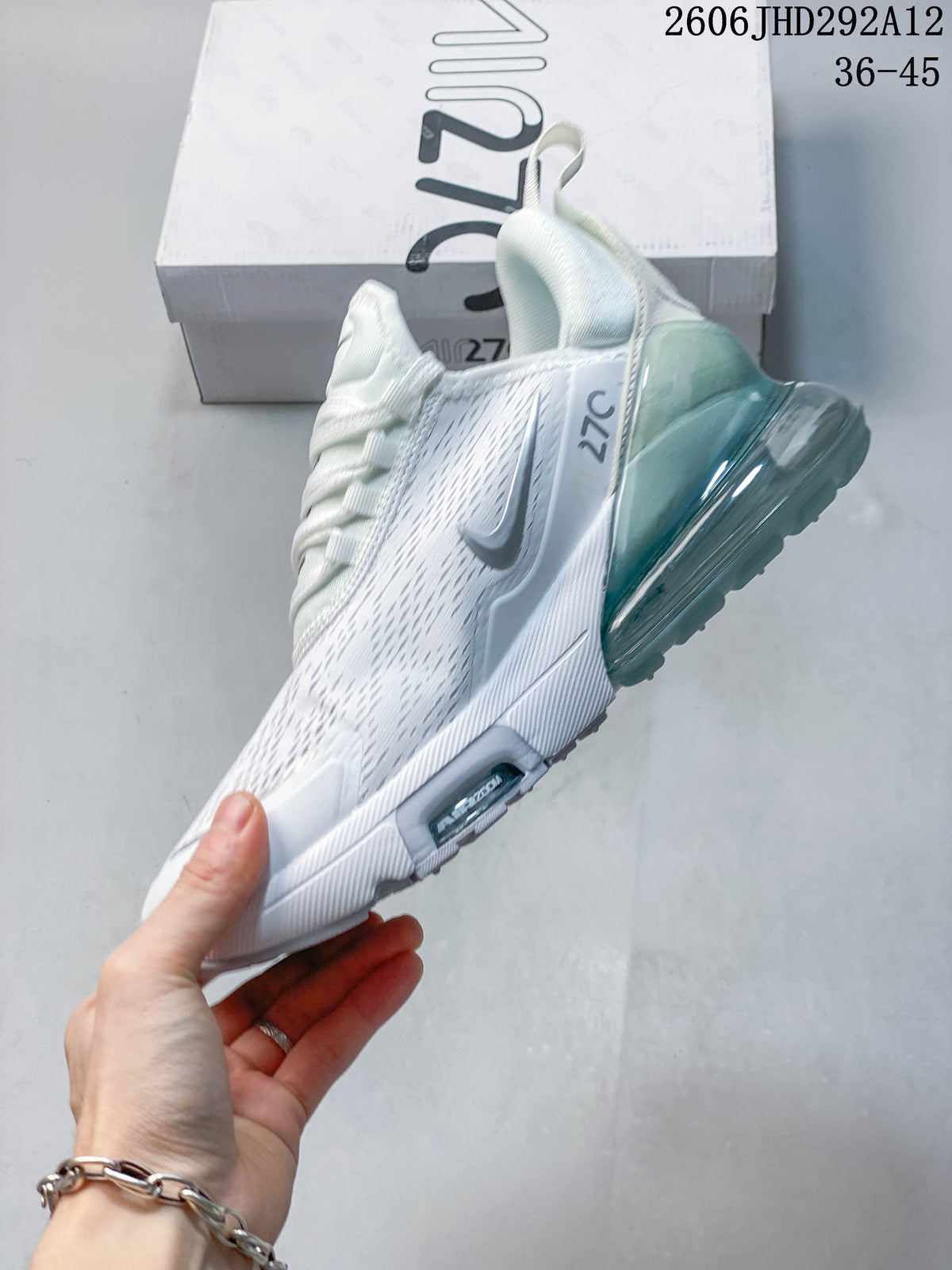 Side profile of the white sneaker with a gray Swoosh and teal-toned heel unit.