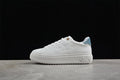 Side view of a white low-top platform sneaker with blue denim-look heel detail