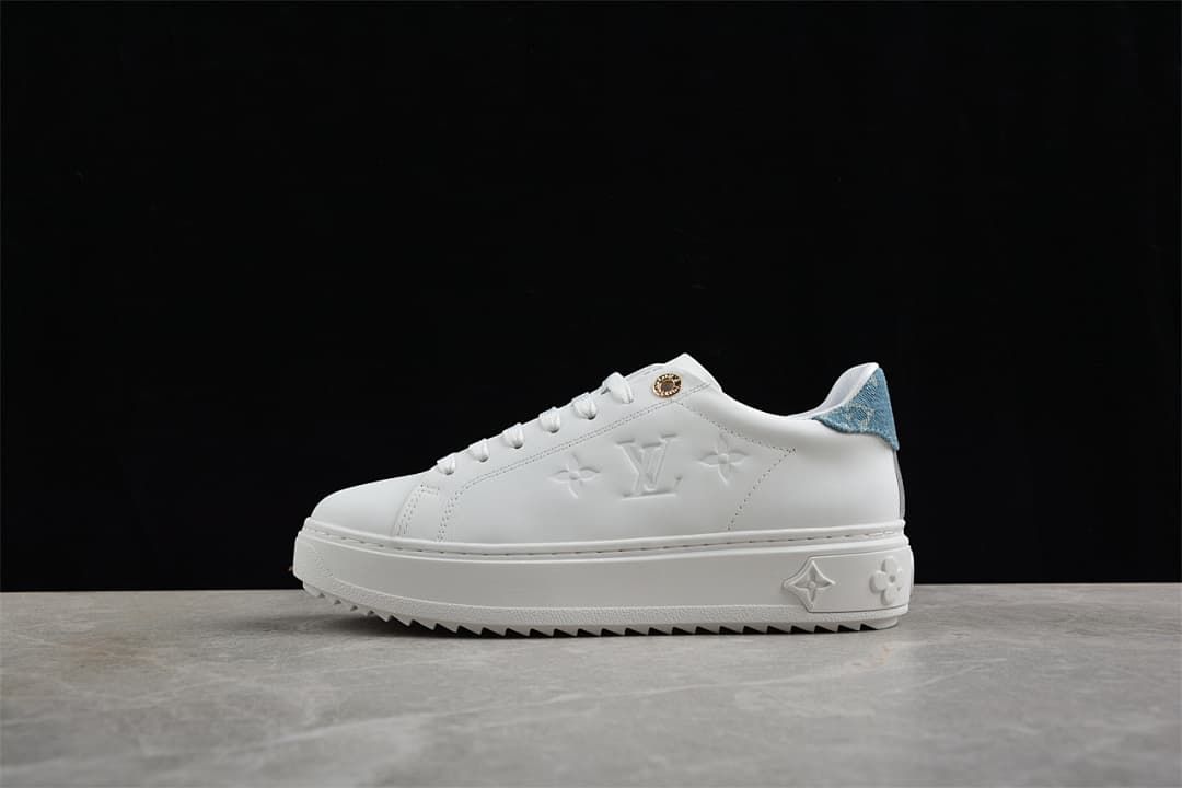 Side view of a white low-top platform sneaker with blue denim-look heel detail