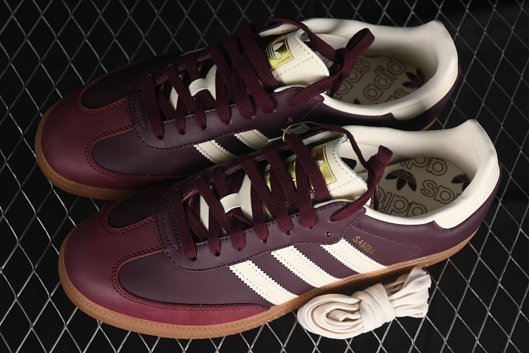 Pair of burgundy and cream Samba OG sneakers with an extra pair of cream laces