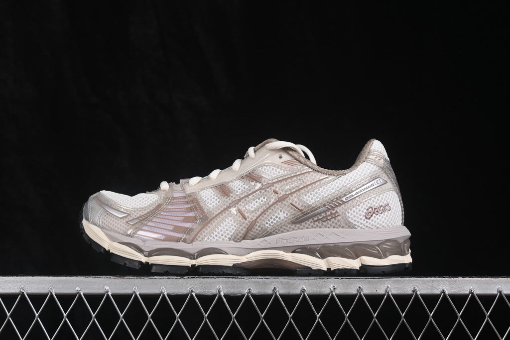 Side profile of cream and gray ASICS Gel-Kayano 12.1 sneakers showing the mesh upper, layered overlays, and cushioned-looking midsole.