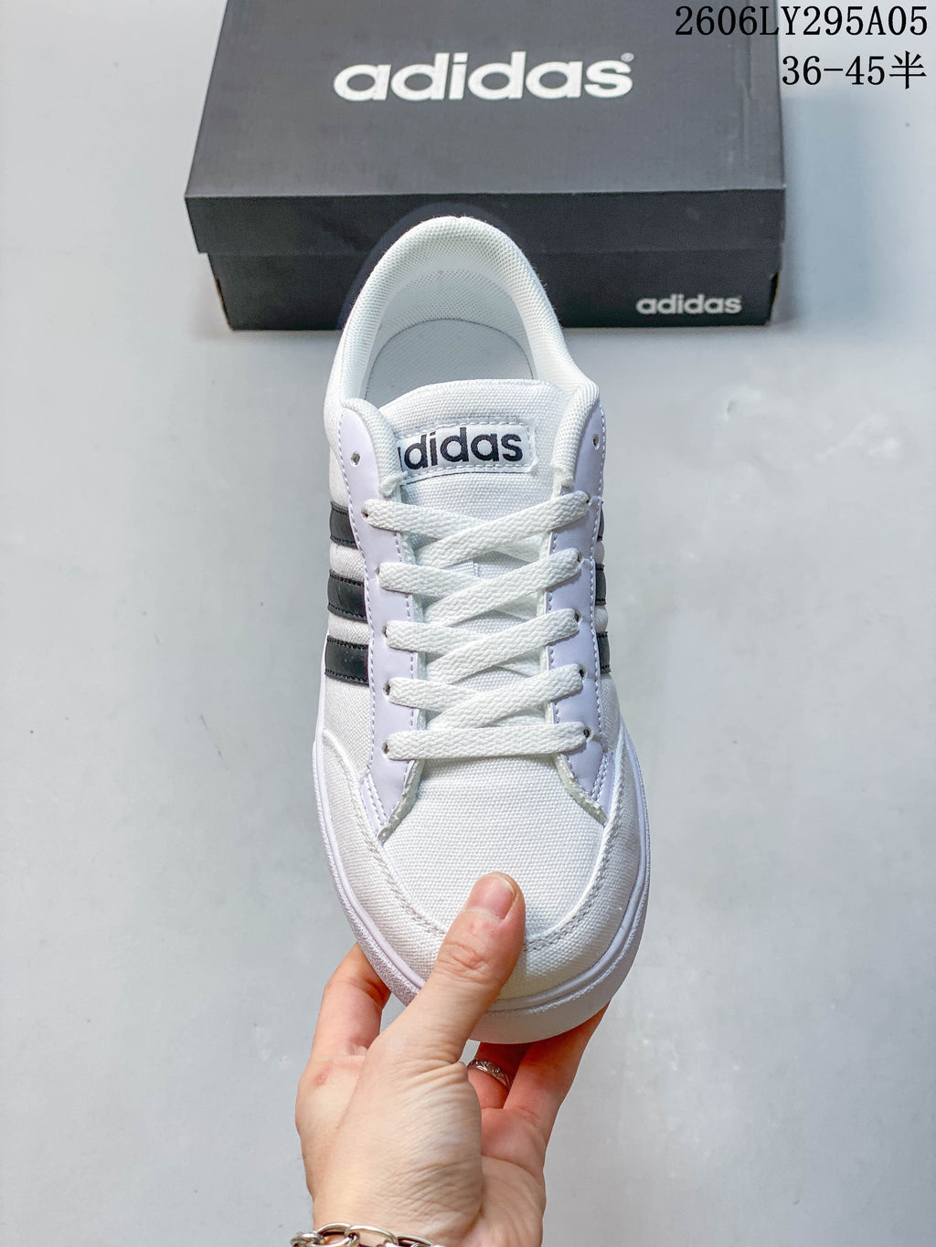Front view of the lace-up sneaker with white upper and dark side stripes