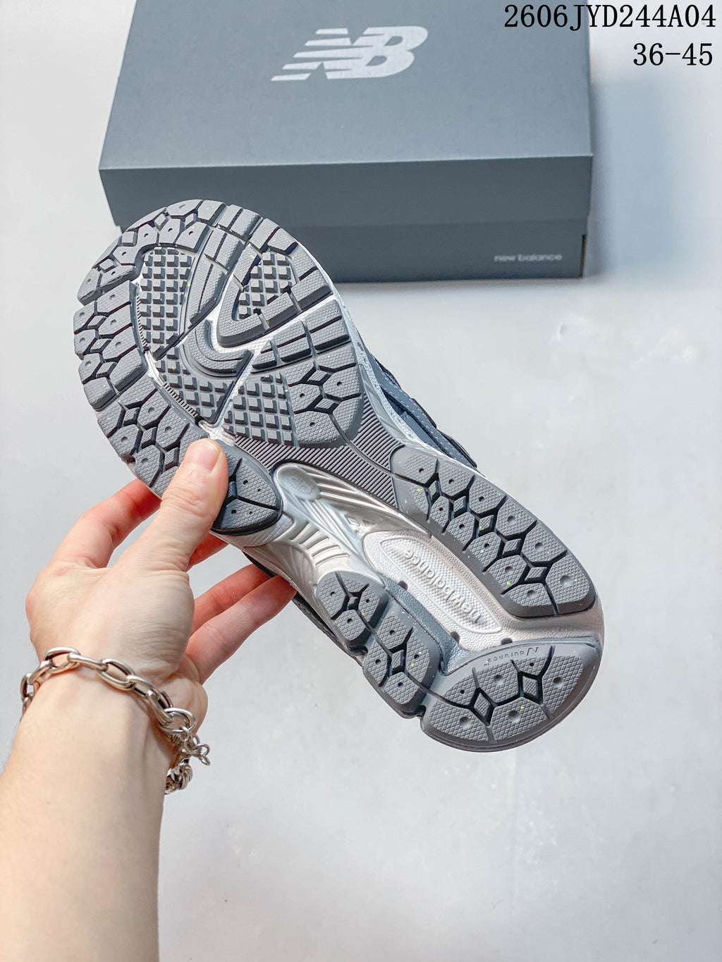 Close-up of the patterned outsole on a gray New Balance 1906R sneaker