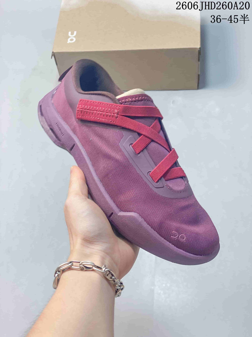 Angled side view of the purple shoe with mesh-like upper and red lace bands