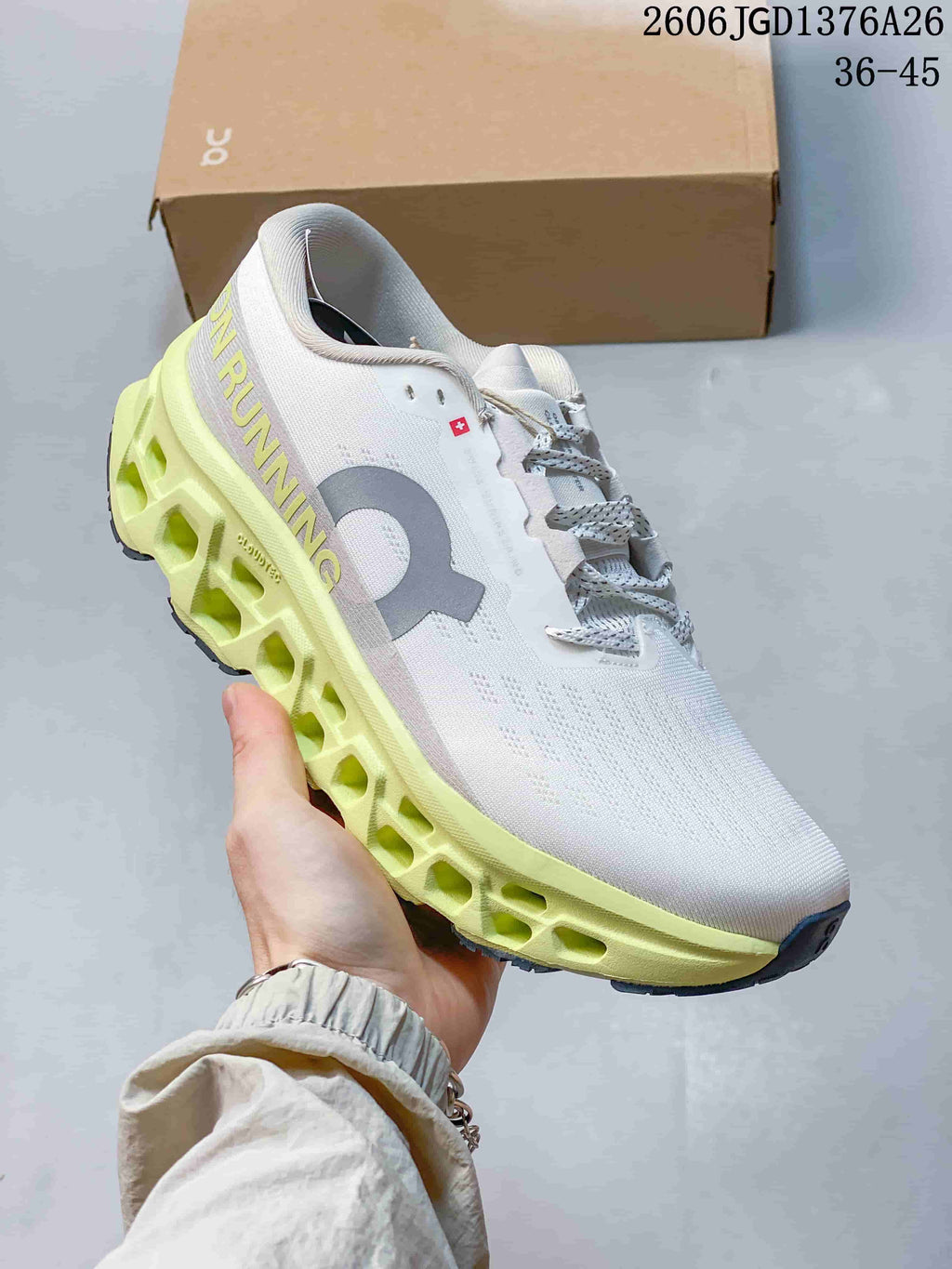 Side view of a white On Cloudmonster 3 shoe with lime open-channel midsole details.