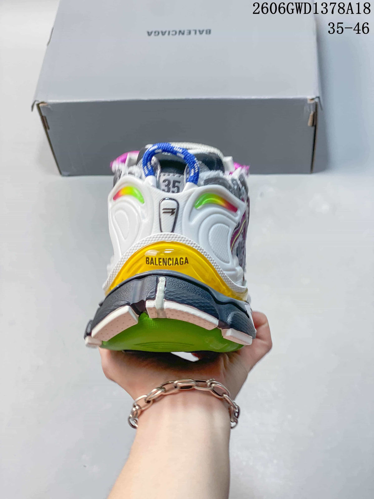 Rear view of a silver Balenciaga Runner sneaker with yellow, green, and dark outsole accents