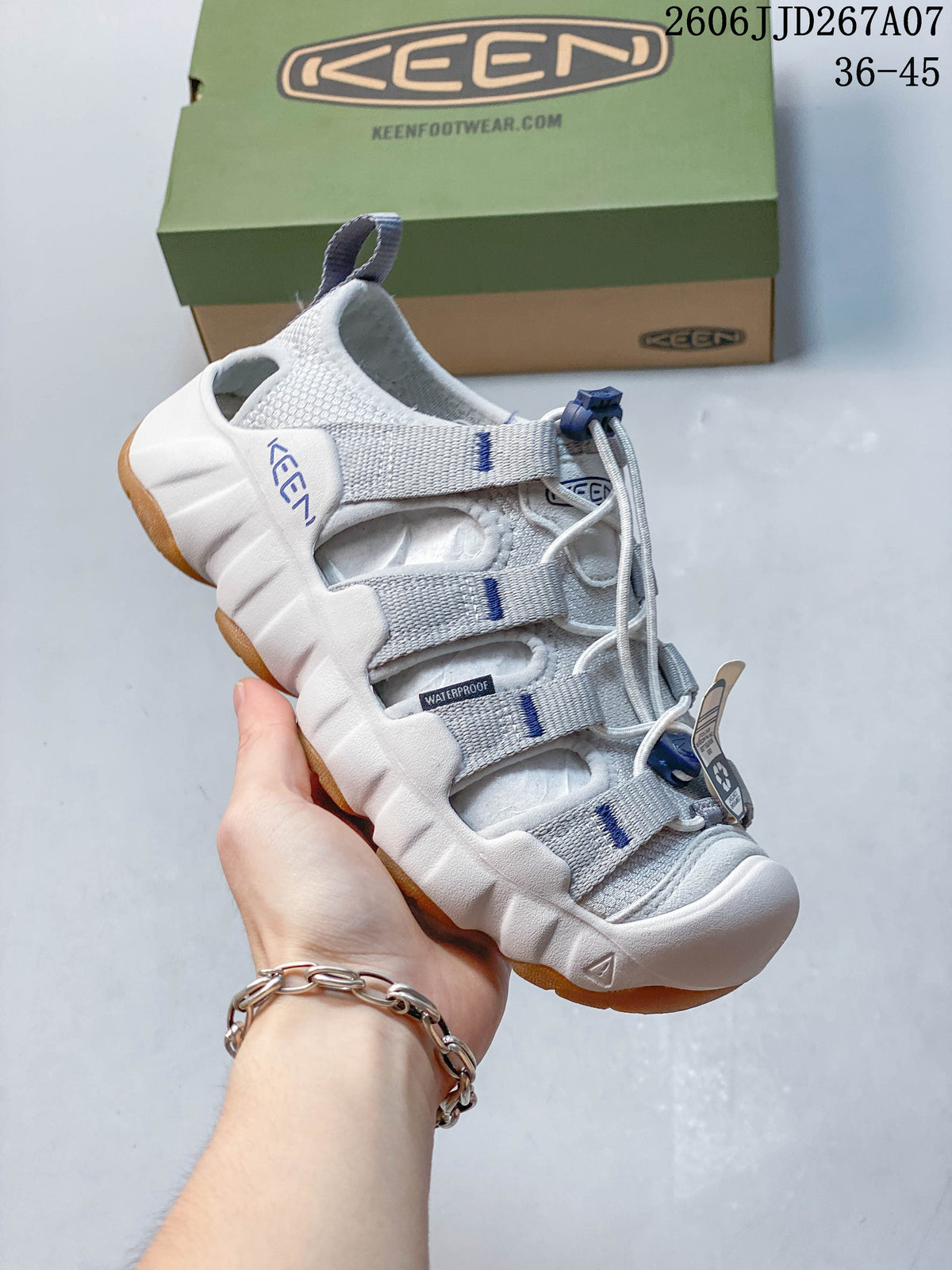 Angled side view of a white and gray sandal with blue accents
