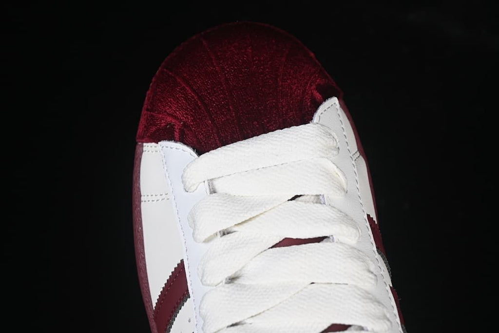 Top-down close-up of the burgundy textured toe and white laces.