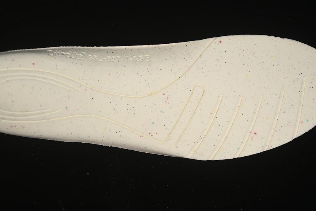 Close-up of the shoe insole showing a speckled surface and molded lines.