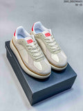 Pair of cream and beige Onitsuka Tiger Delecity low-top sneakers with red accents, shown on a shoebox