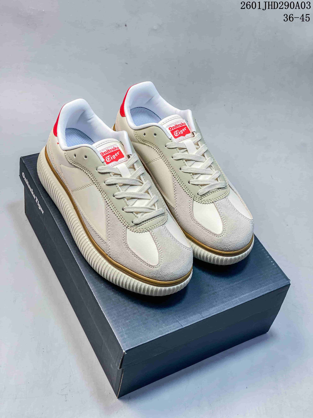 Pair of cream and beige Onitsuka Tiger Delecity low-top sneakers with red accents, shown on a shoebox