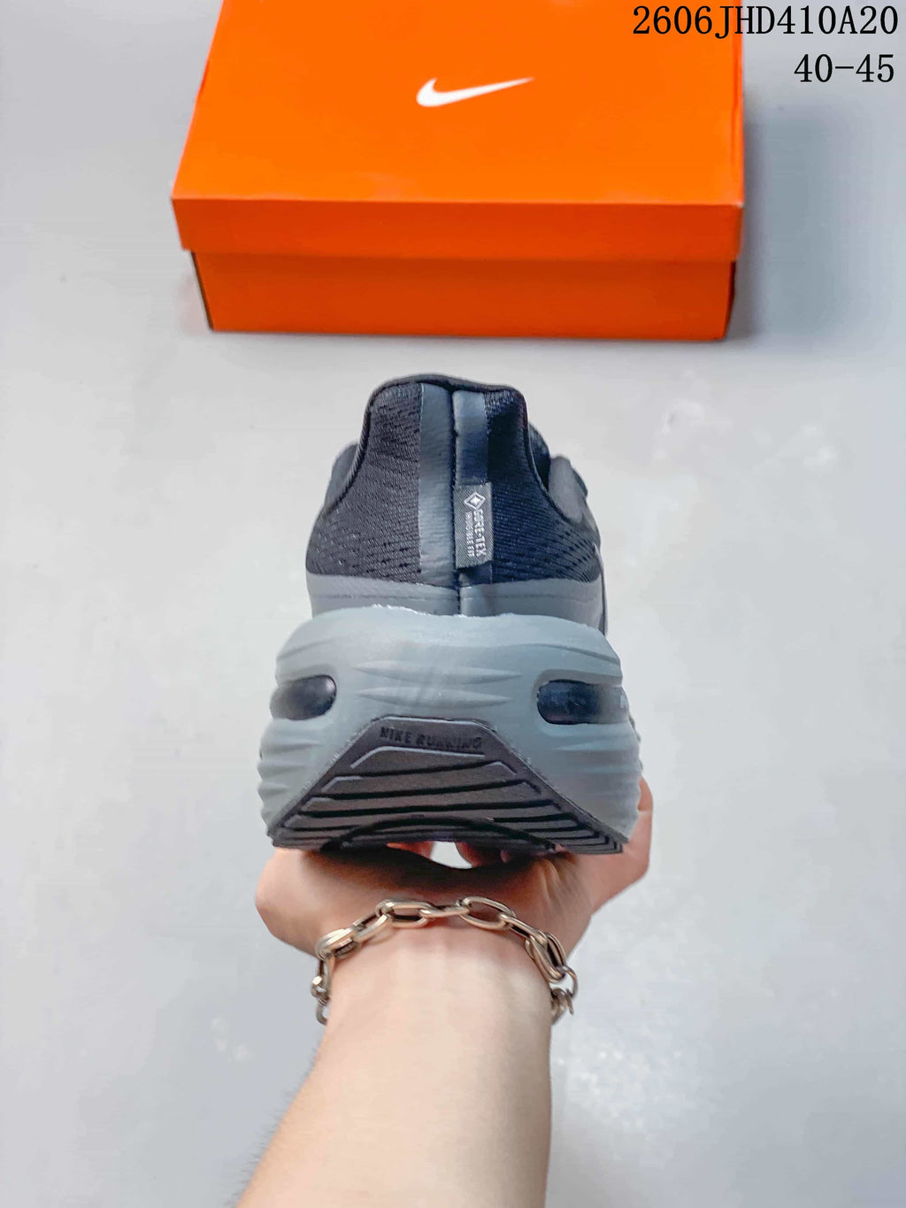 Rear view showing the heel and sculpted midsole of a dark gray running shoe