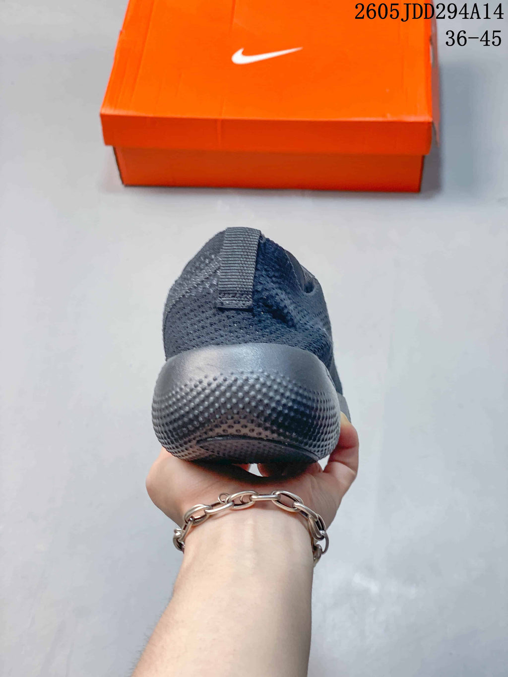 Rear view showing the heel and textured outsole of the dark gray shoe