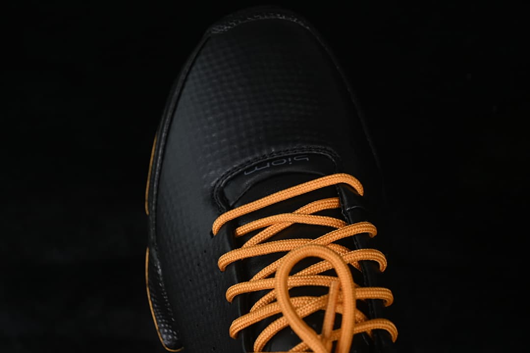 Top-down close-up of the black toe and orange lace-up front