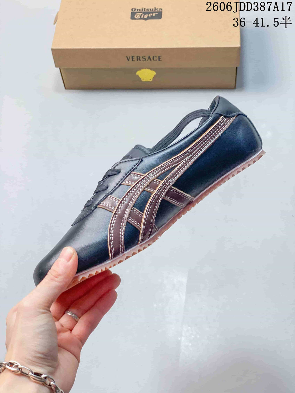Side profile showing dark navy upper, brown stripes, and pale pink outsole