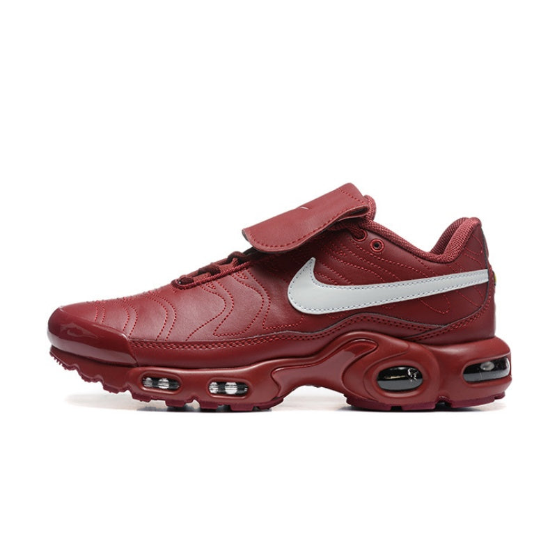 Red Nike Air Max Plus sneaker with a large white swoosh and strap across the upper.