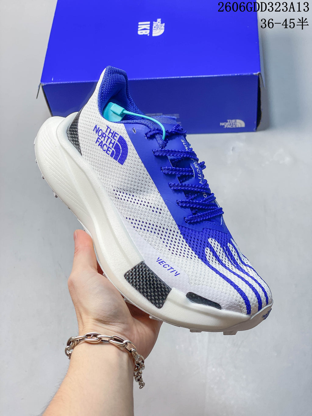 Side and front view of the gray-and-white adidas running shoe with blue accents