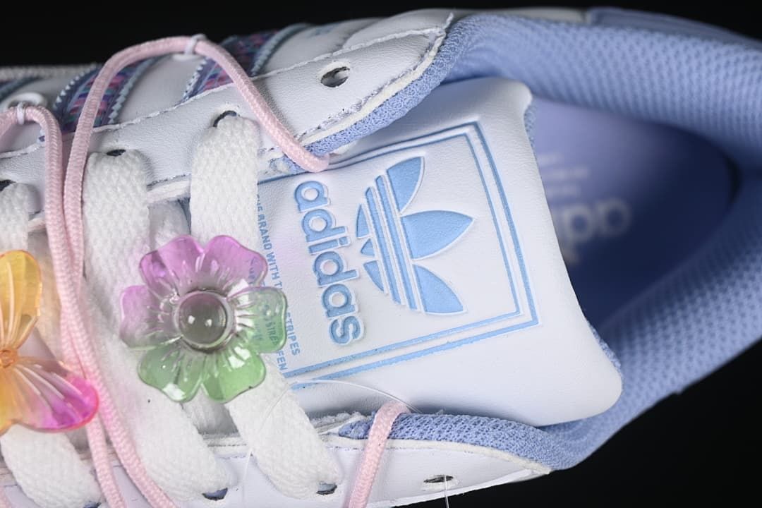 Close-up of the adidas tongue patch and decorative flower lace charm