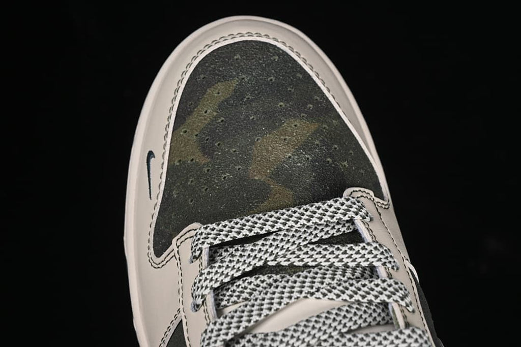 Top-down close-up of the camouflage-patterned toe and laces