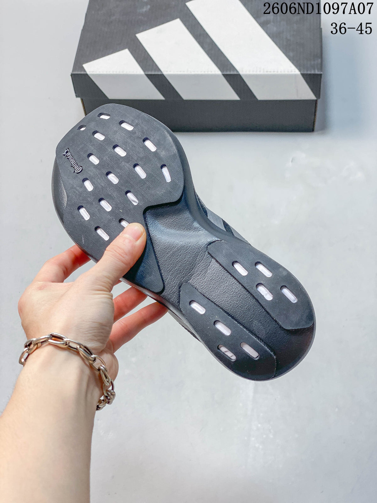 Underside of a dark gray running shoe showing its outsole and patterned openings.
