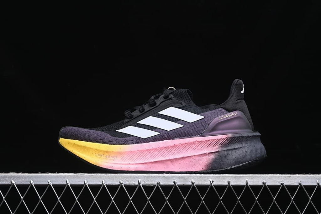Side view of a black and purple adidas Ultraboost 5X with white stripes and a pink-to-yellow midsole.