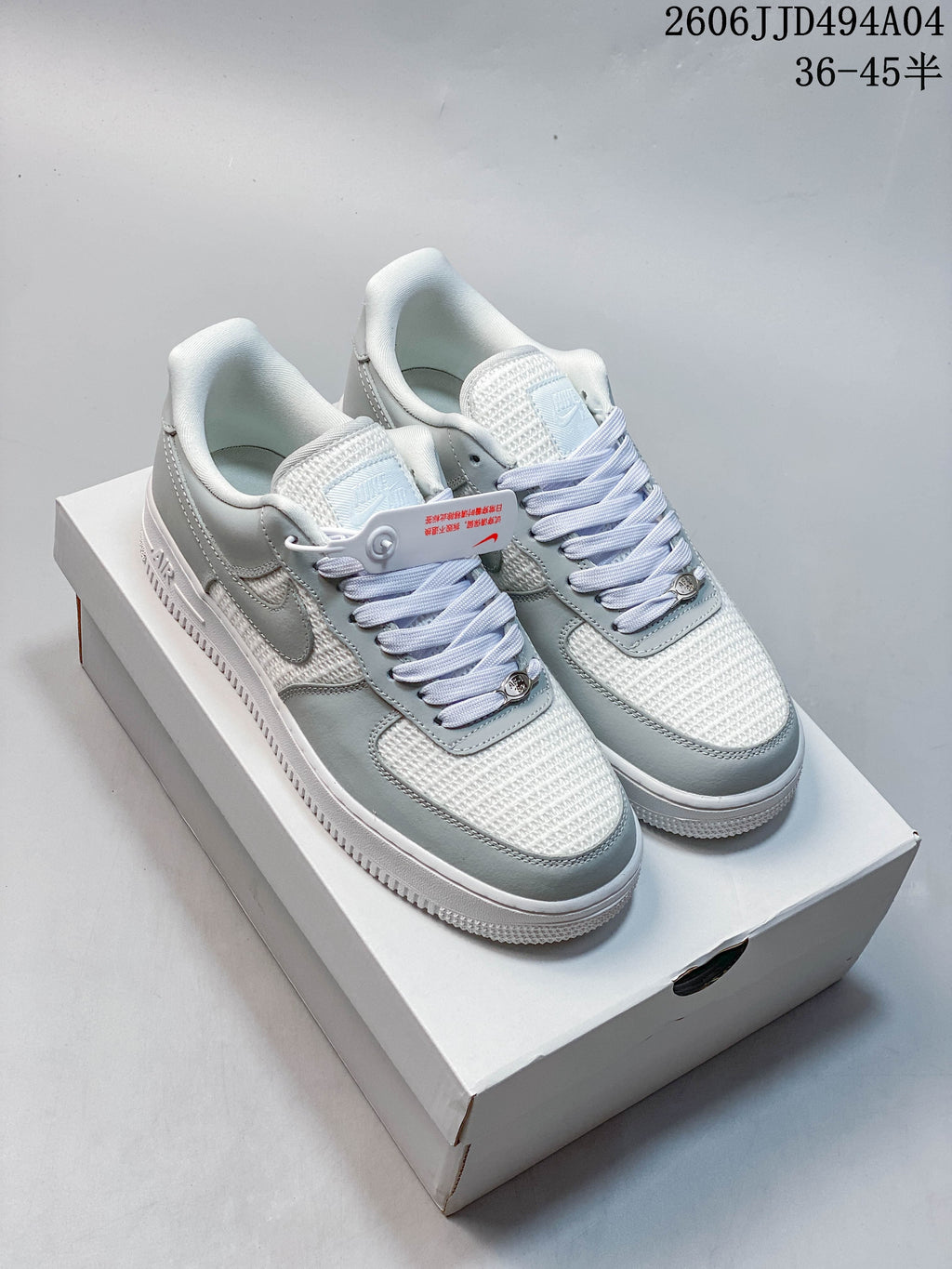 Pair of white and light gray Nike Air Force 1 '07 Low sneakers on a shoe box