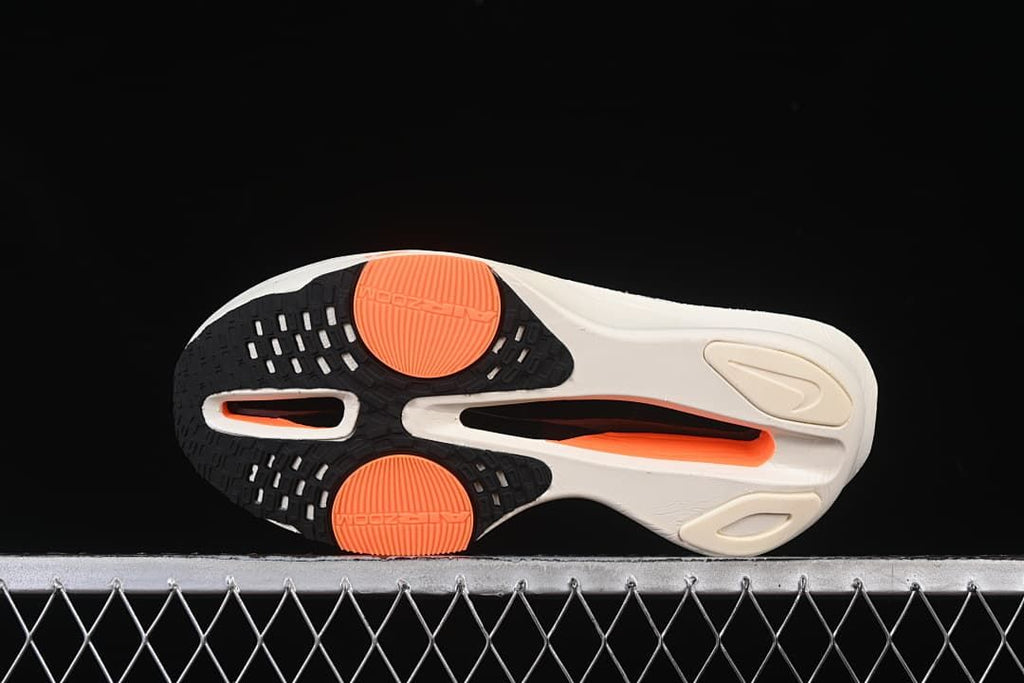 Underside view showing the outsole and orange traction details