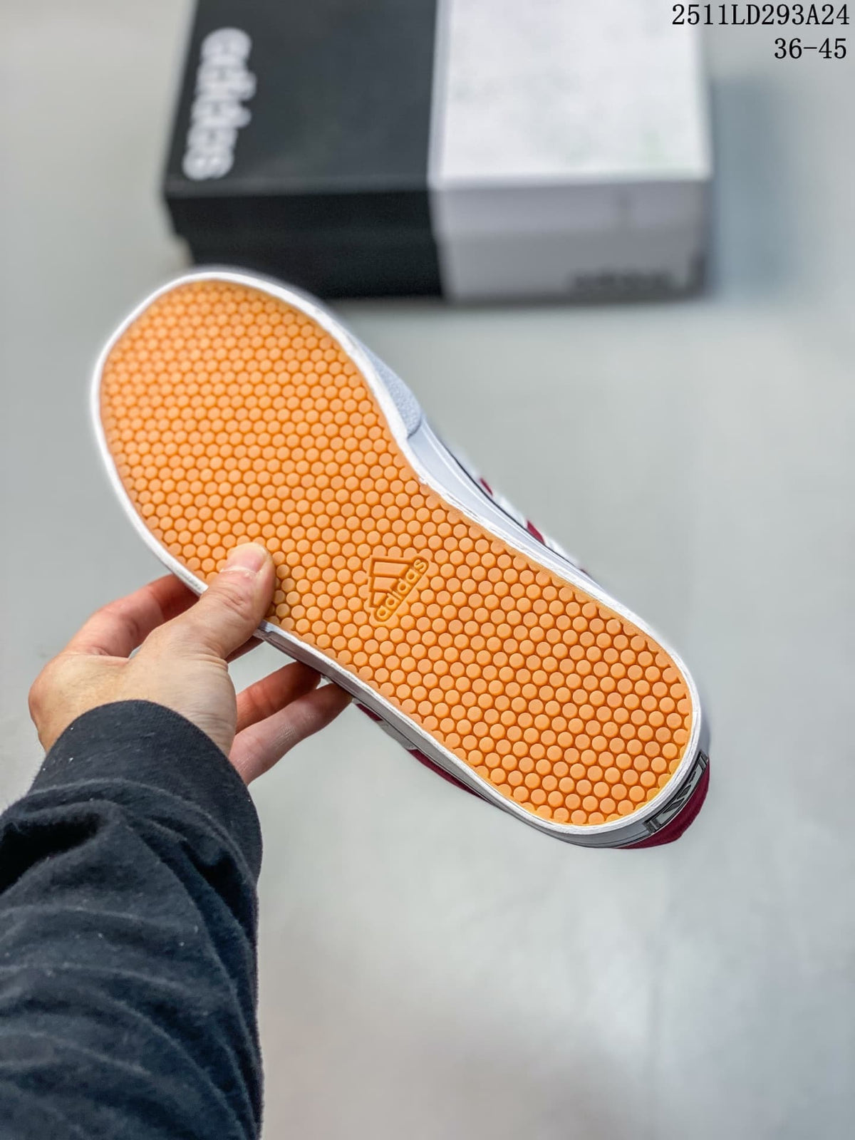 Close-up of the orange textured outsole on a burgundy sneaker