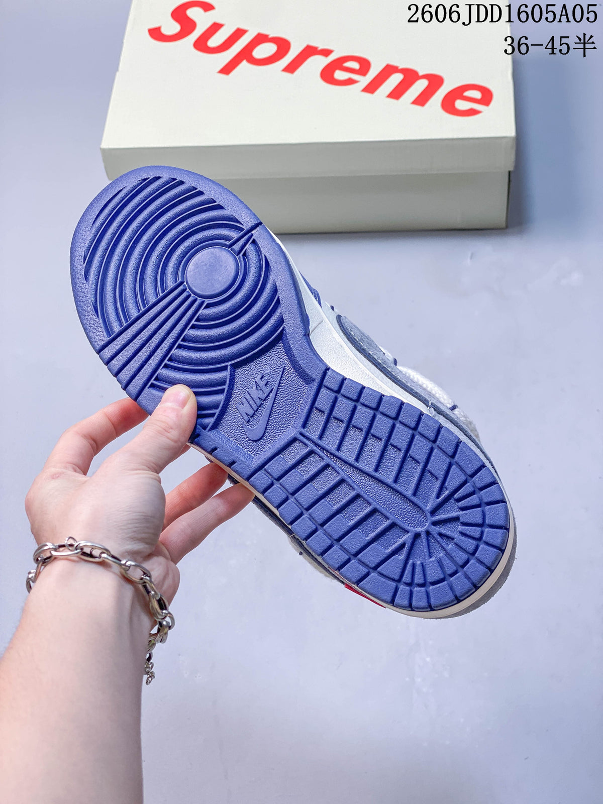 Blue outsole of a low-top sneaker with a branded box in the background