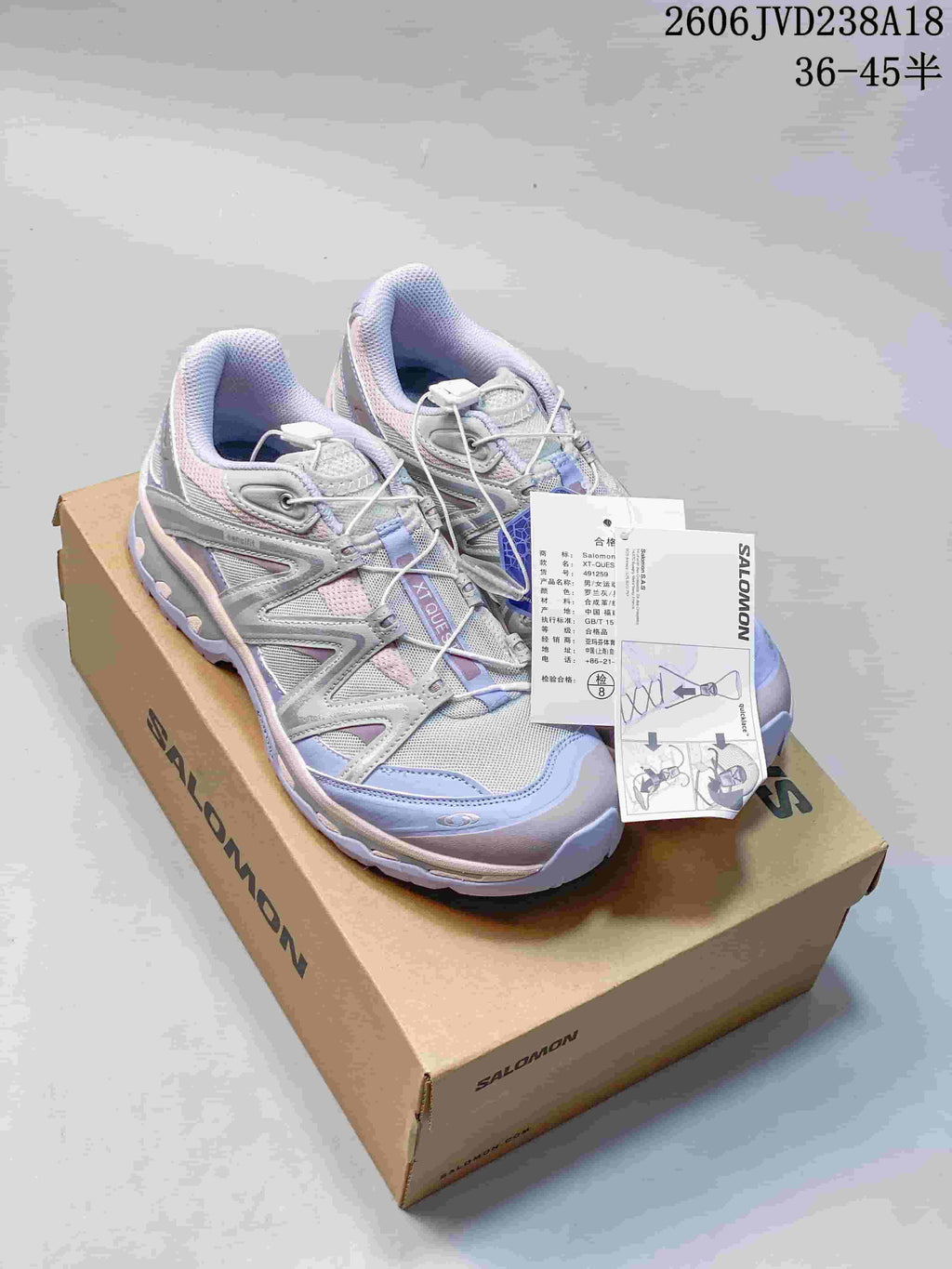 Salomon XT-Quest ATHR sneakers on a shoebox, showing the silver, lavender and pale pink colorway.