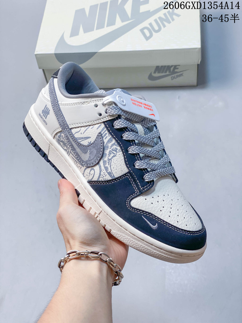 Angled side view of the white, navy, and gray low-top sneaker