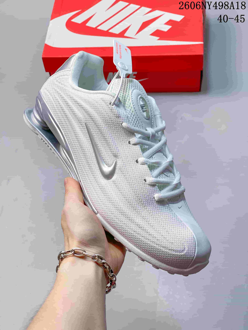 Angled view of a white and silver Nike Shox TL sneaker