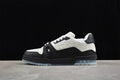 Side view of a black and white Louis Vuitton Trainer-style sneaker against a dark backdrop.
