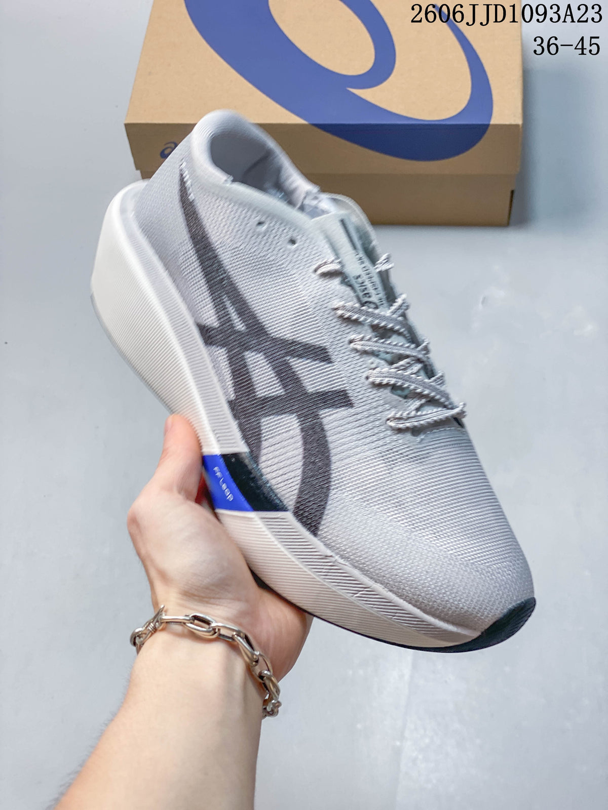 Side view of a light gray ASICS running shoe with a dark logo and pale sole