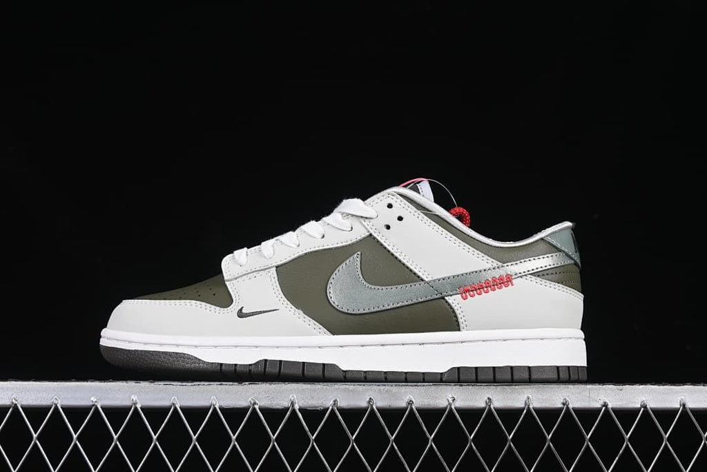 Side profile of the white and olive Nike SB Dunk Low with metallic silver Swoosh.