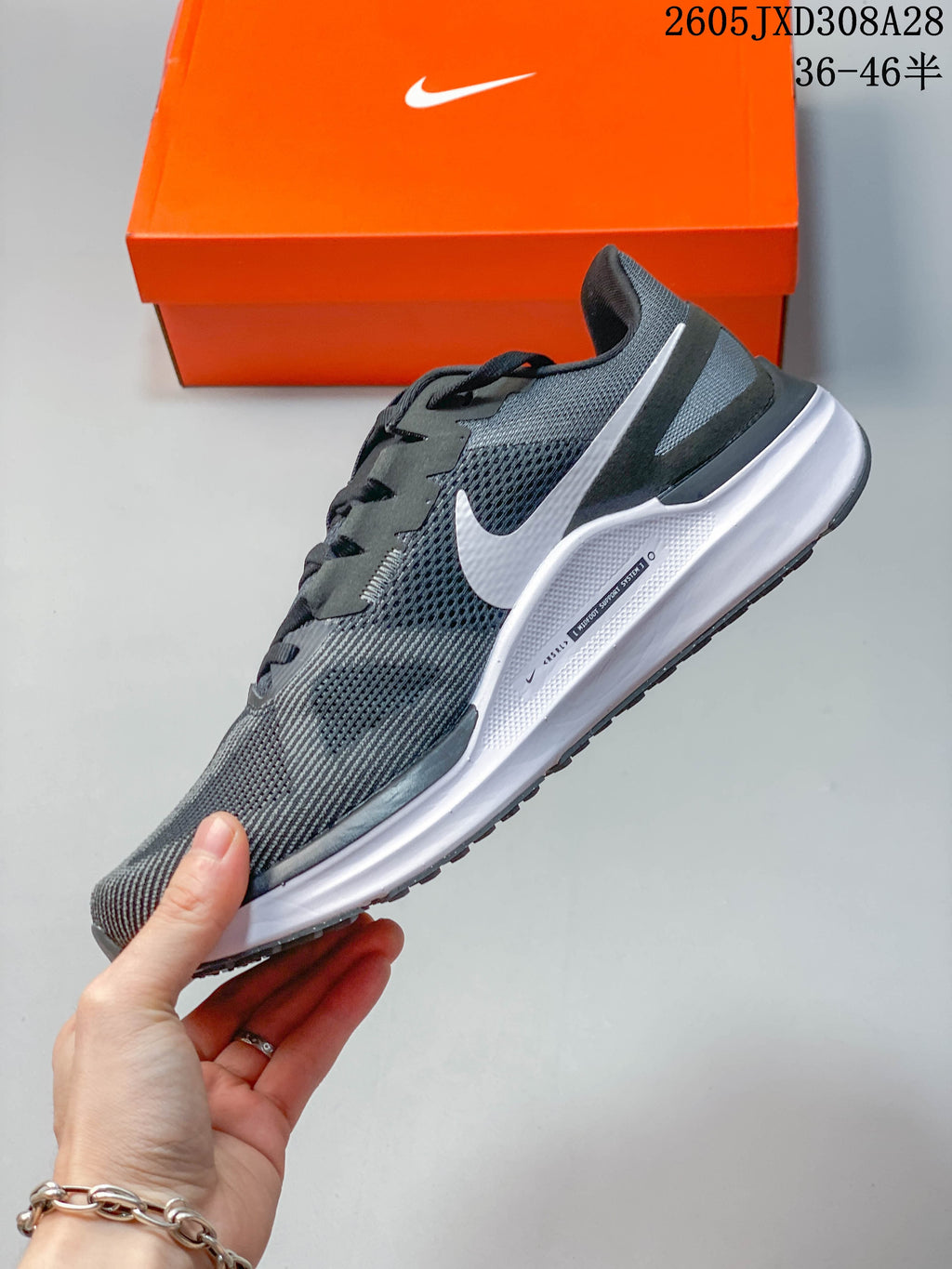 Side profile of a gray Nike Air Zoom Structure 25 running shoe with a white midsole.