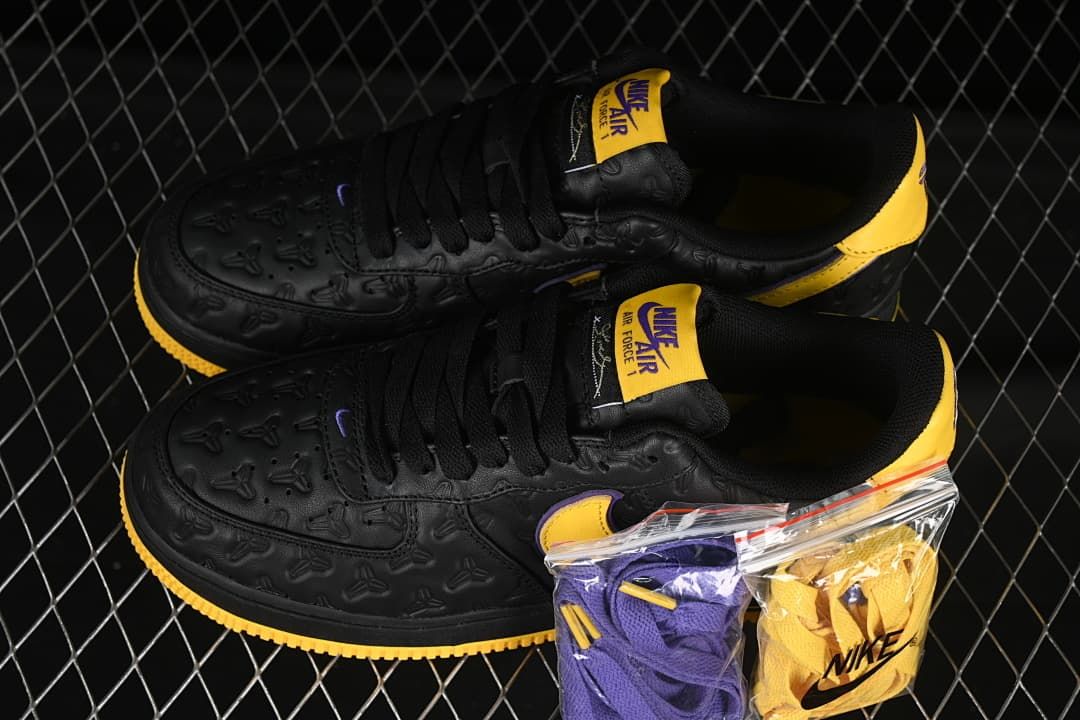 Pair of black, yellow, and purple low-top sneakers with spare laces.