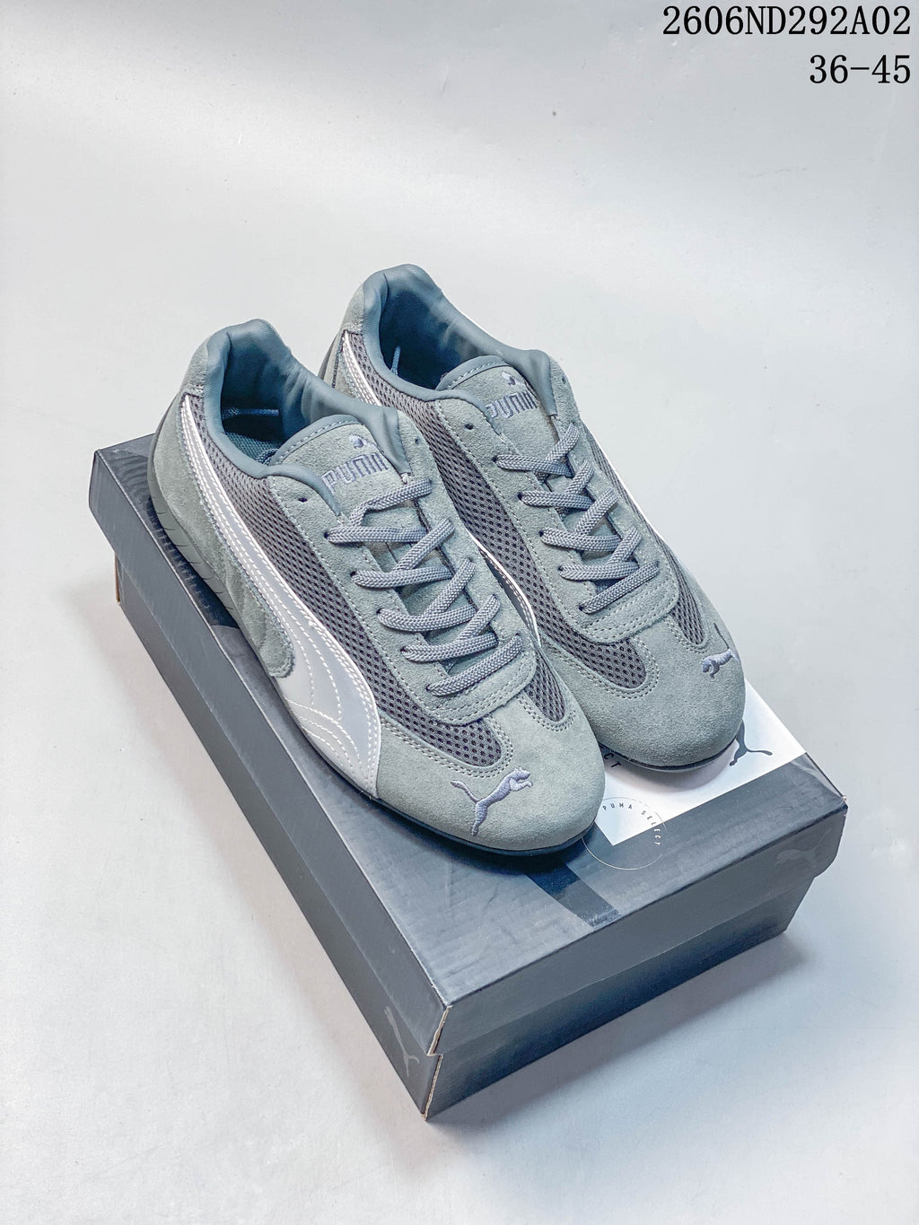 Pair of gray Puma Speedcat The Open YY sneakers on a shoebox