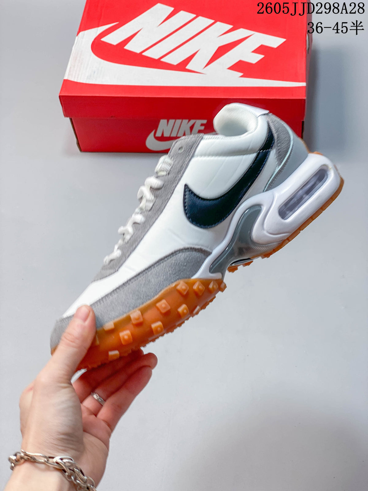 Side profile of a white and grey Nike Air Max Waffle SP sneaker with dark Swoosh and gum outsole.
