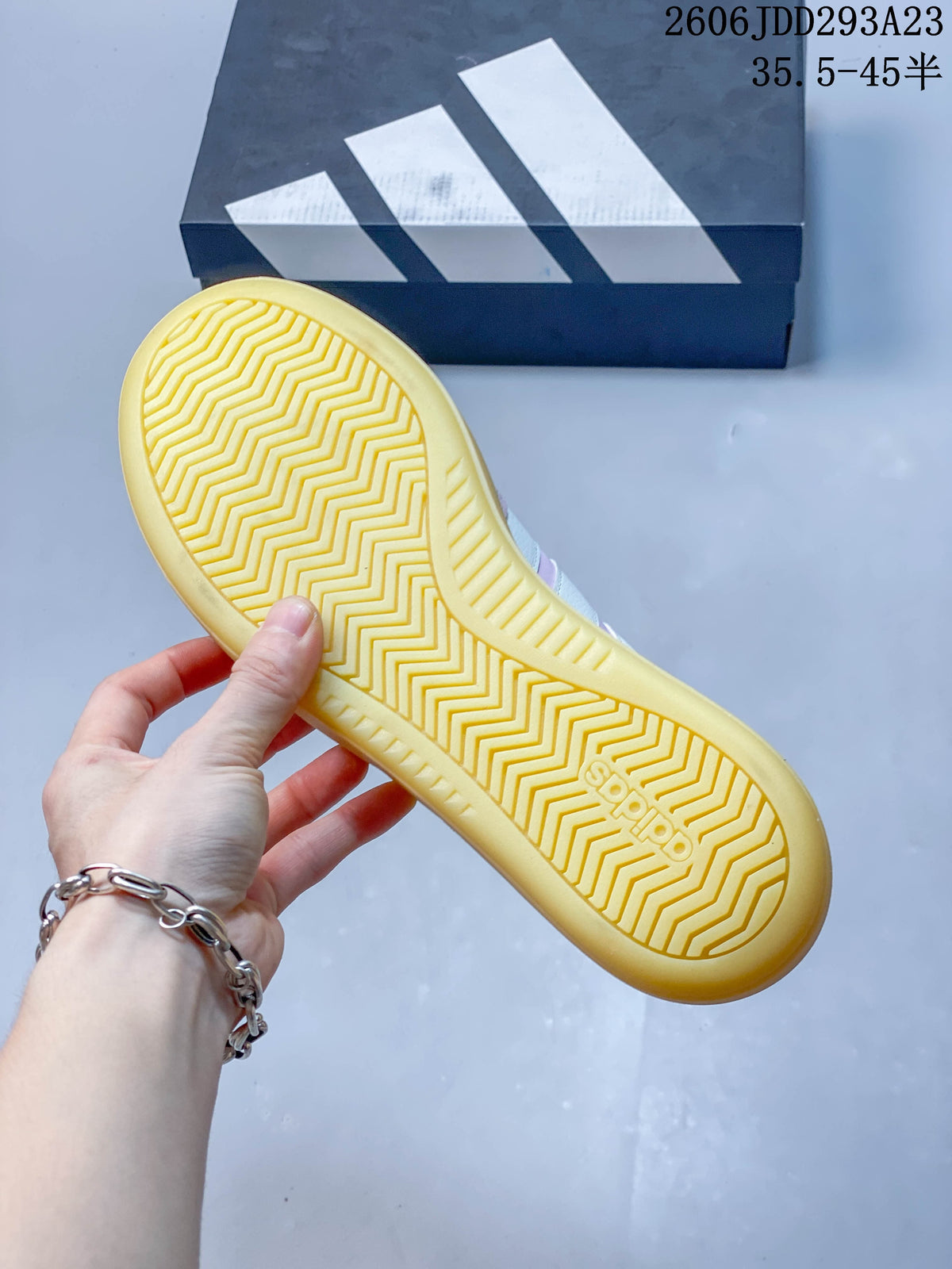 Underside of the sneaker showing a zigzag tread pattern on the gum-colored sole