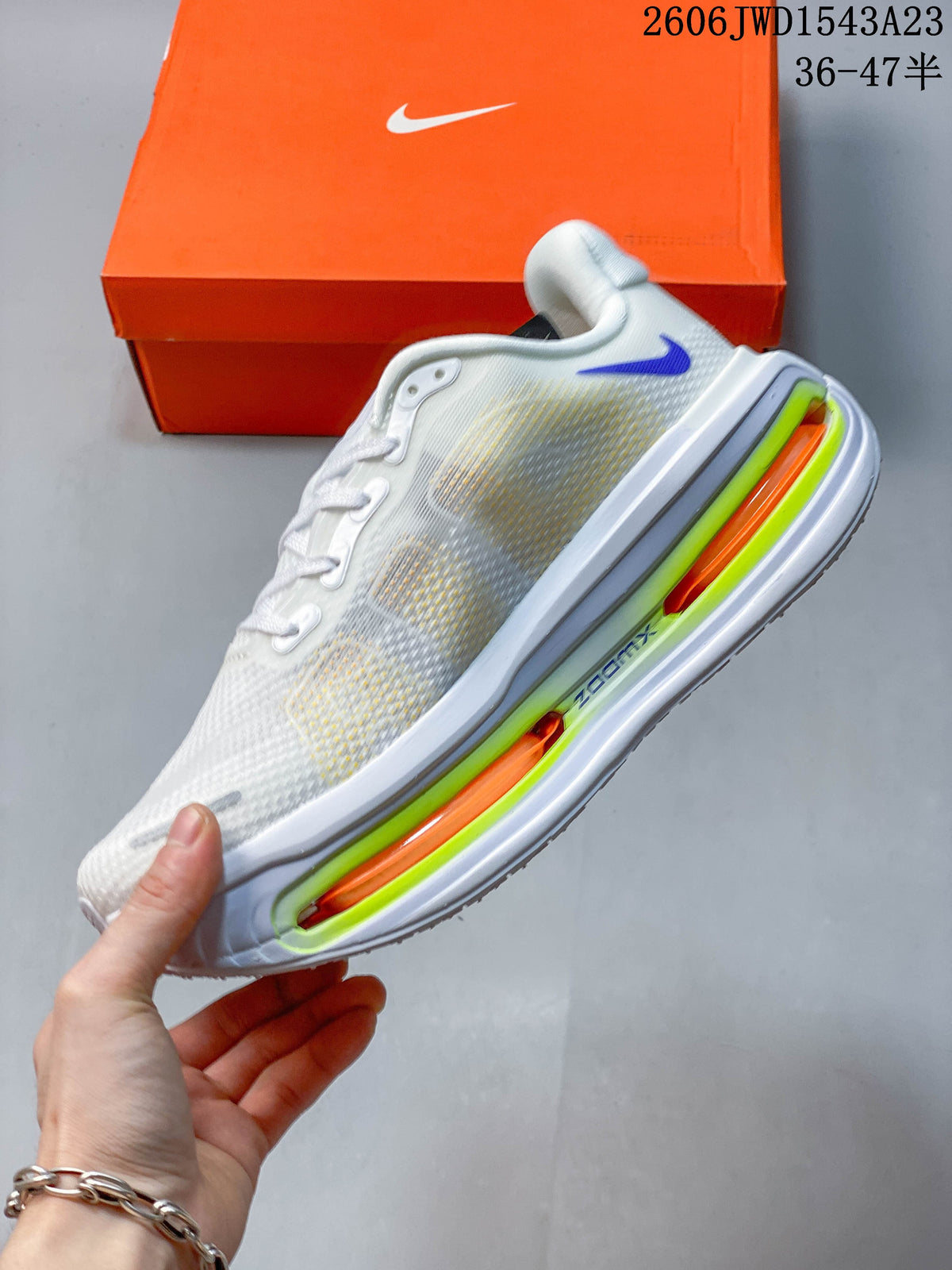 Side view of the white low-top running shoe with blue accent and lime and orange sole details