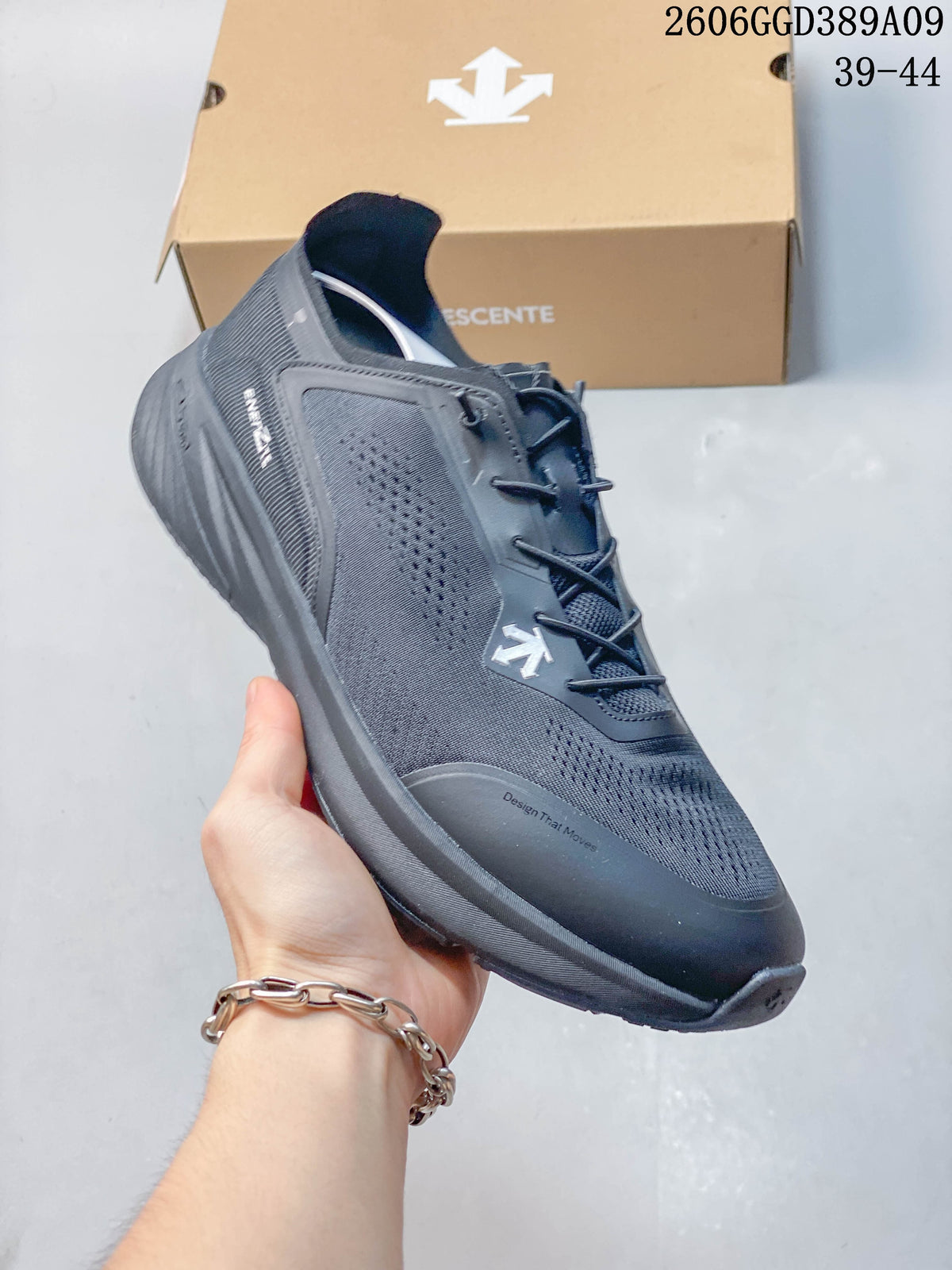 Angled side view of a dark gray Descente running shoe with perforated panels and a thick sole.