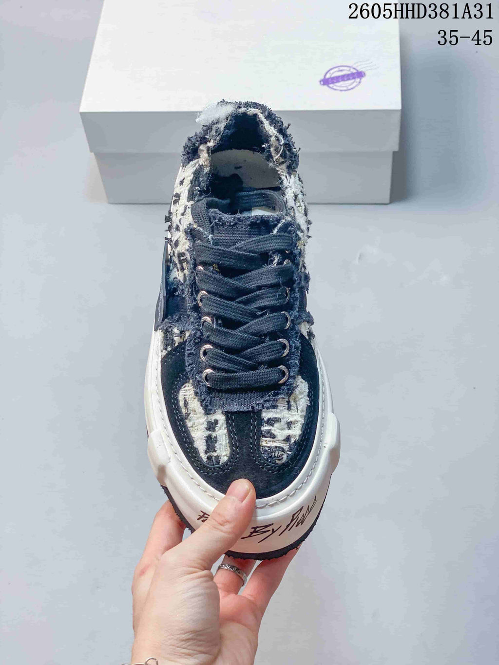 Top-down view of the sneaker showing dark laces and layered navy and cream panels.