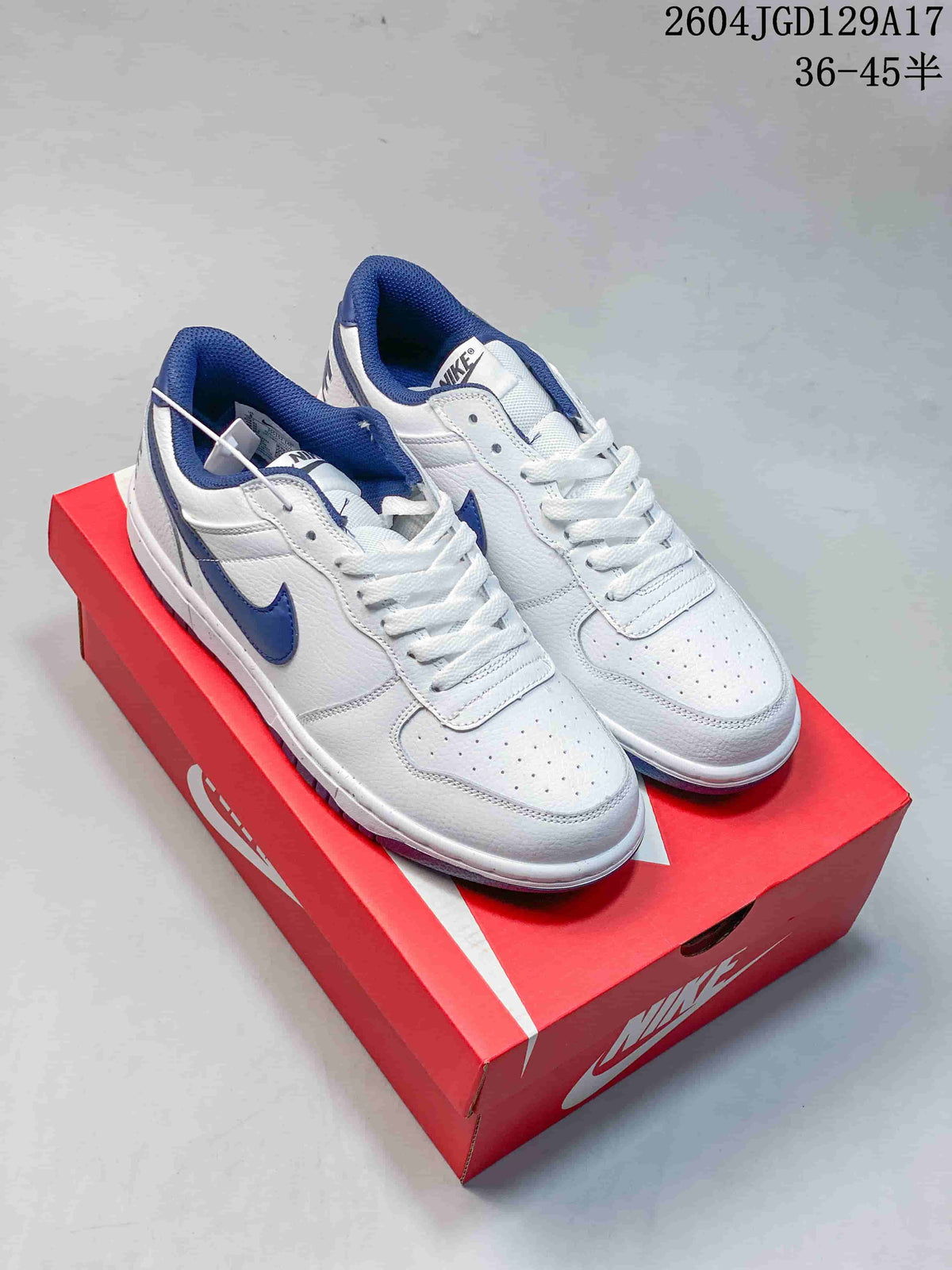White Nike Big Low sneakers with blue Swooshes and blue collar lining on a red shoe box.