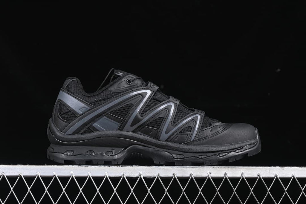 Side profile of the black trail shoe with dark gray overlays.
