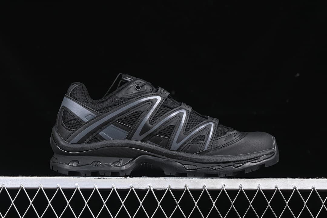 Side profile of the black trail shoe with dark gray overlays.